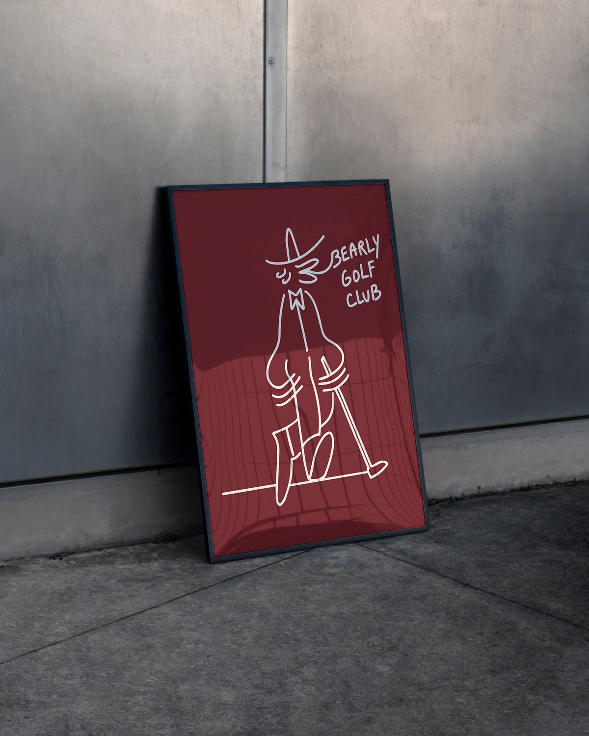Framed maroon Gus Gus Golf Club 50x70cm art print leaning against a wall